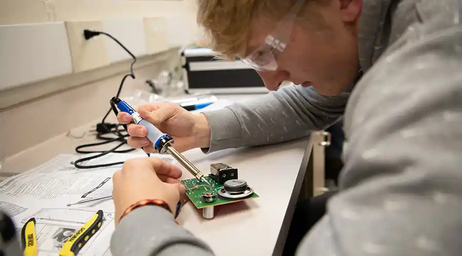 Professor working with students in a classroom