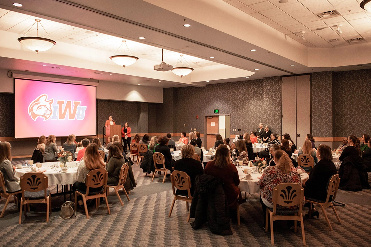 A banquet room filled with people seated at round tables