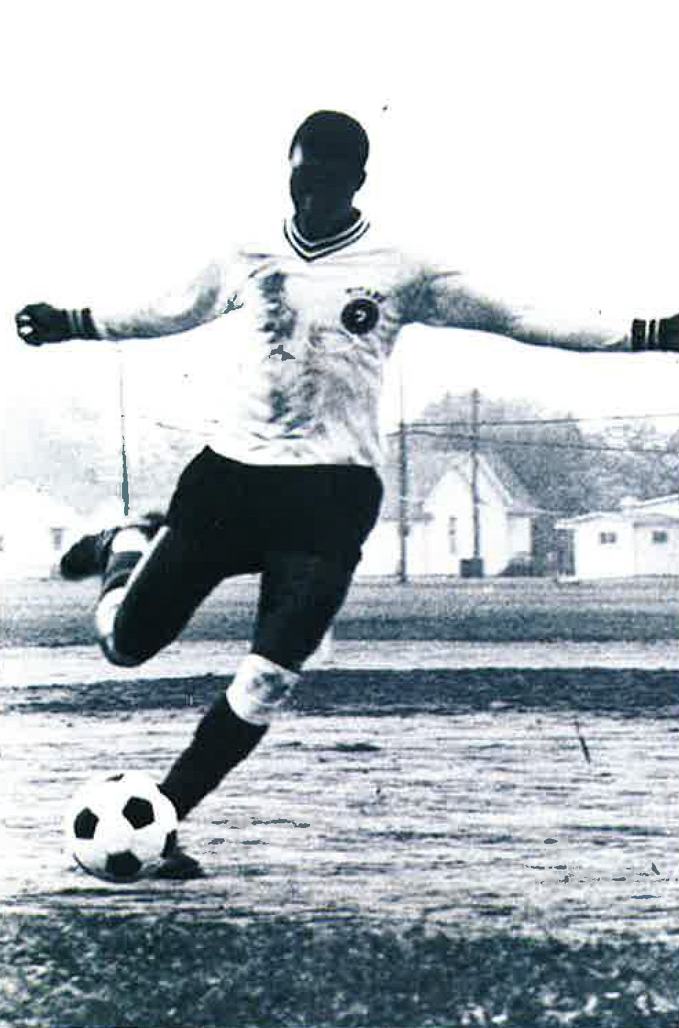 A young Francis Mustapha prepares to kick a soccer ball.