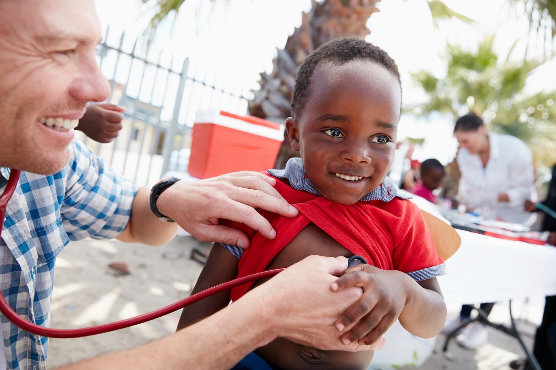 A nurse holds a stethoscope to a child's chest