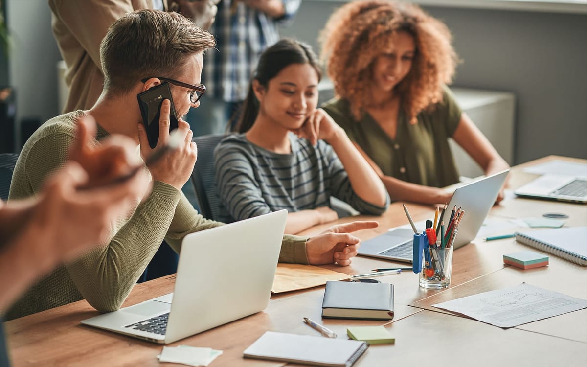 A group of people working together on laptop at a table