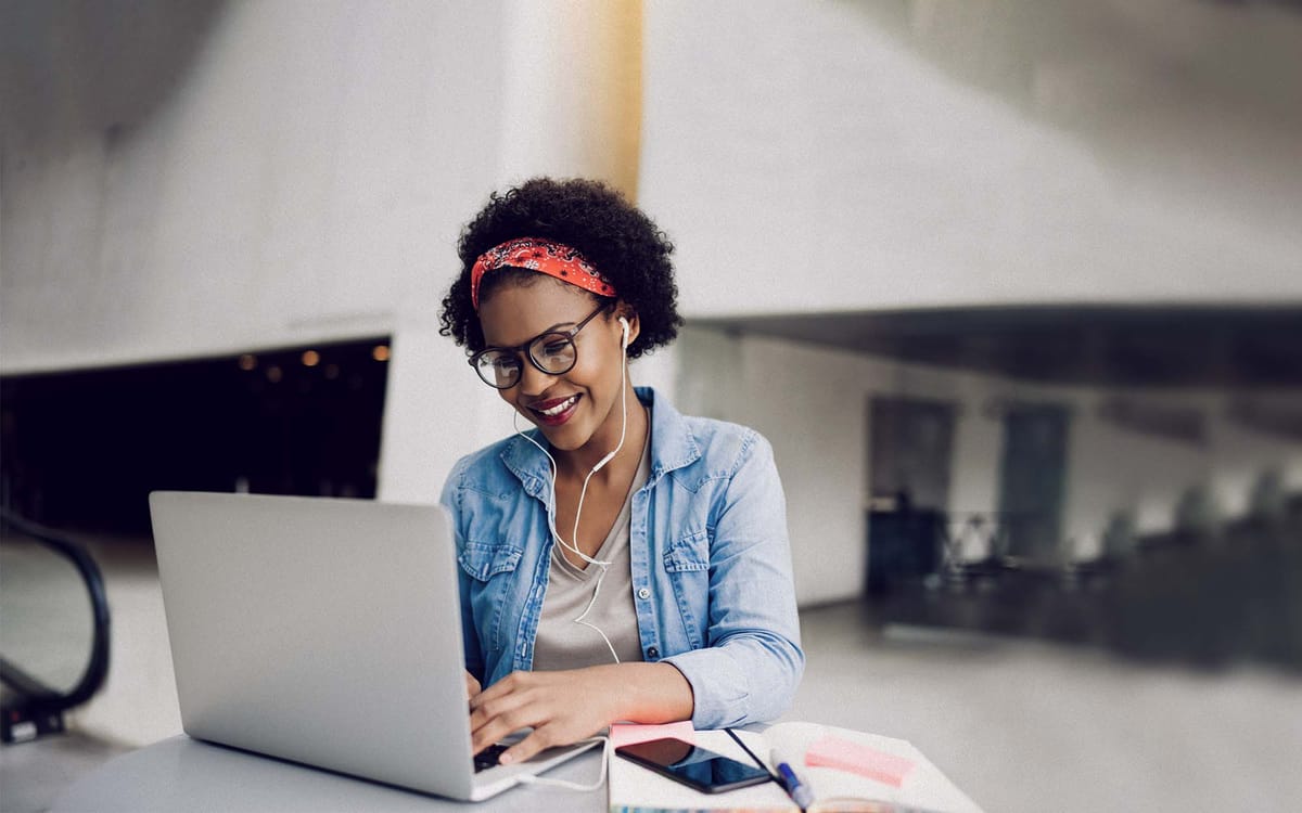 Woman working on computer with headphones in