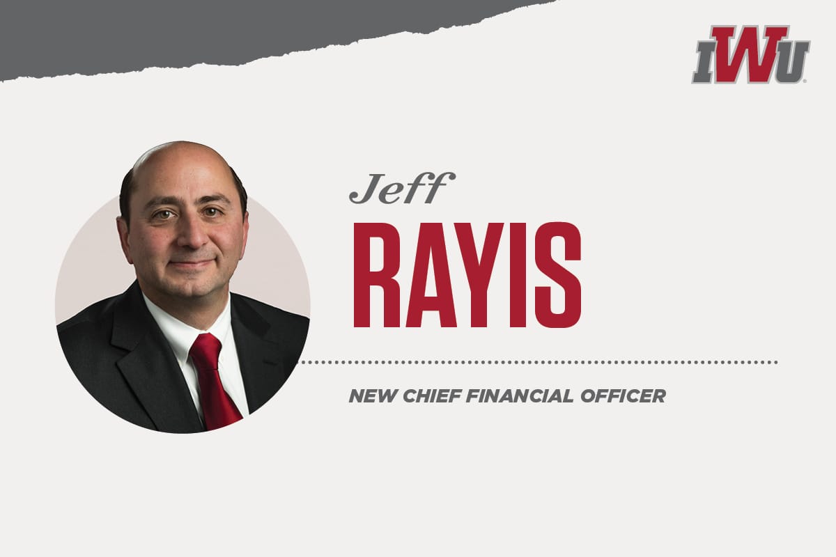 Female student smiling with another female student in front of a computer