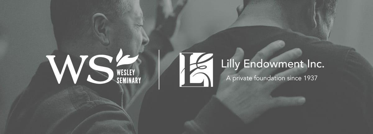 Female student smiling with another female student in front of a computer