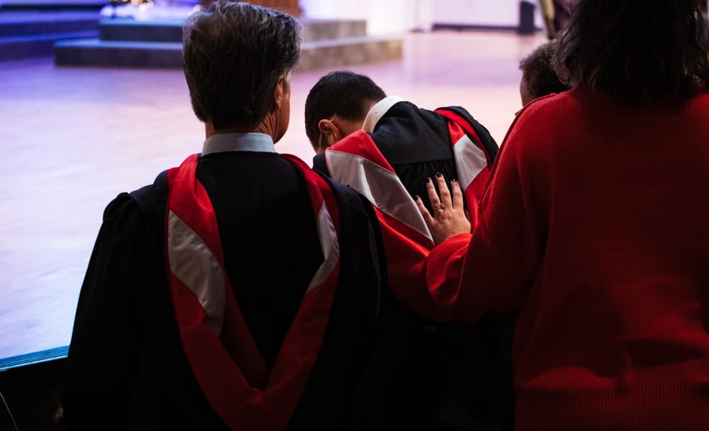 Graduates and attendees gathered near the stage during a ceremony.