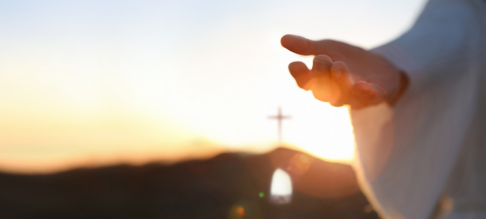 Hands held open with sunset in background