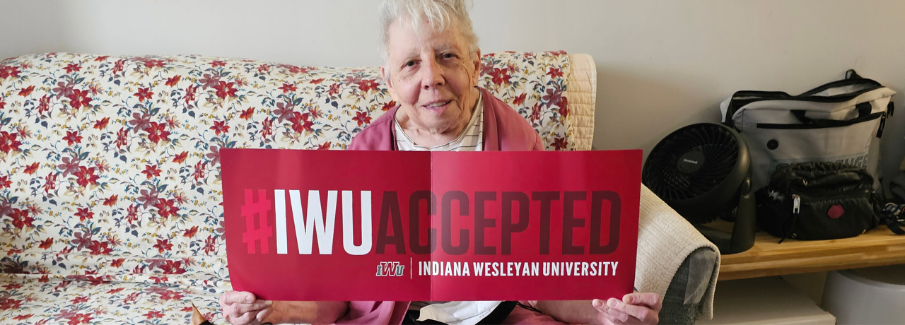 Marcy holding a "#IWU Accepted" sign