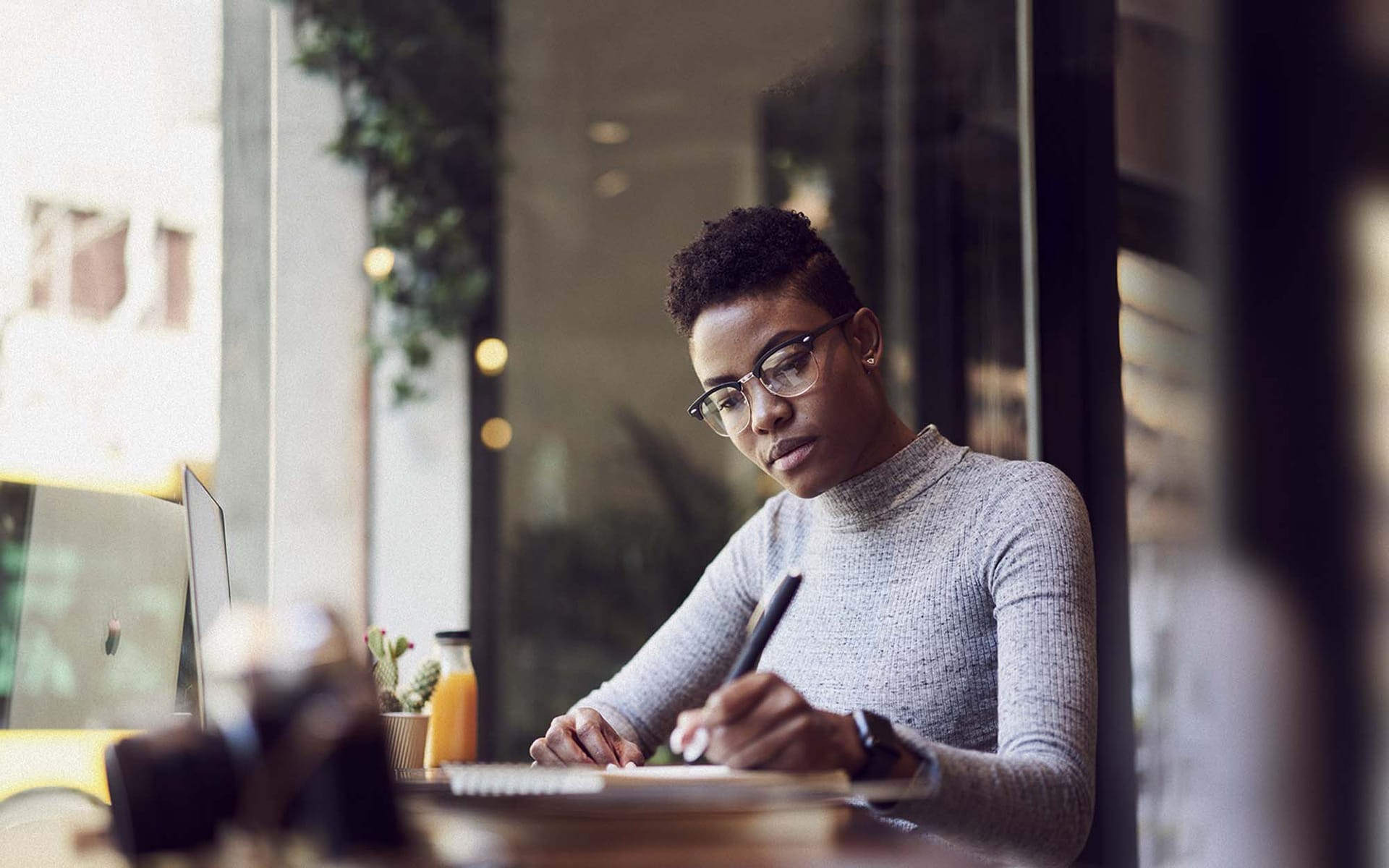 Woman writing in notebook at table
