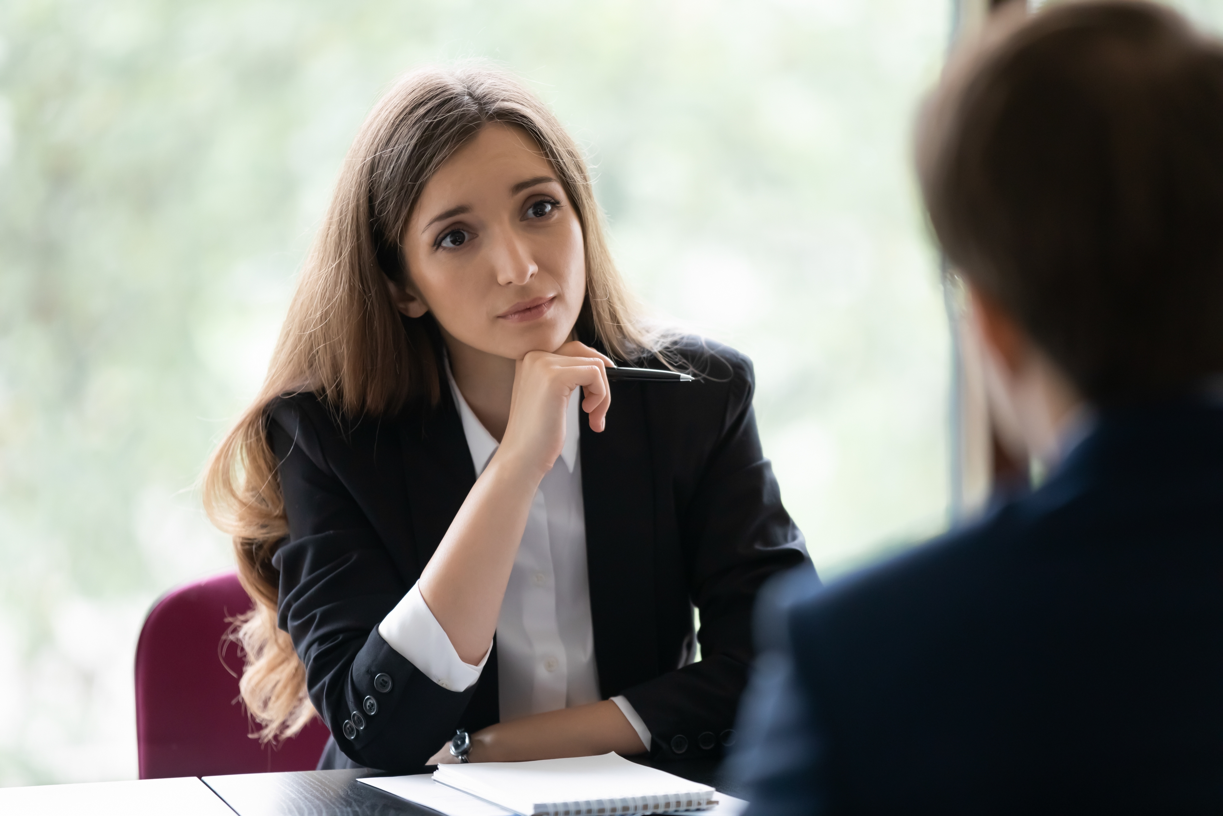 Business woman listening to another person in office with look of concern or concentration 
