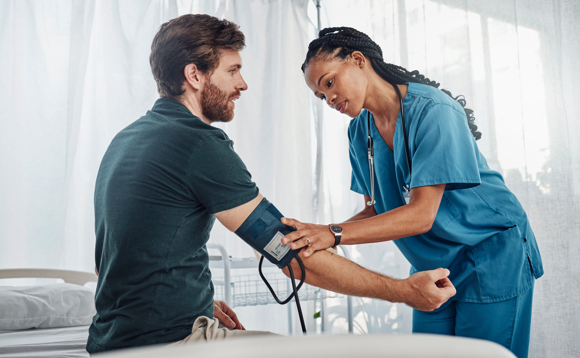Nurse checking man's blood pressure
