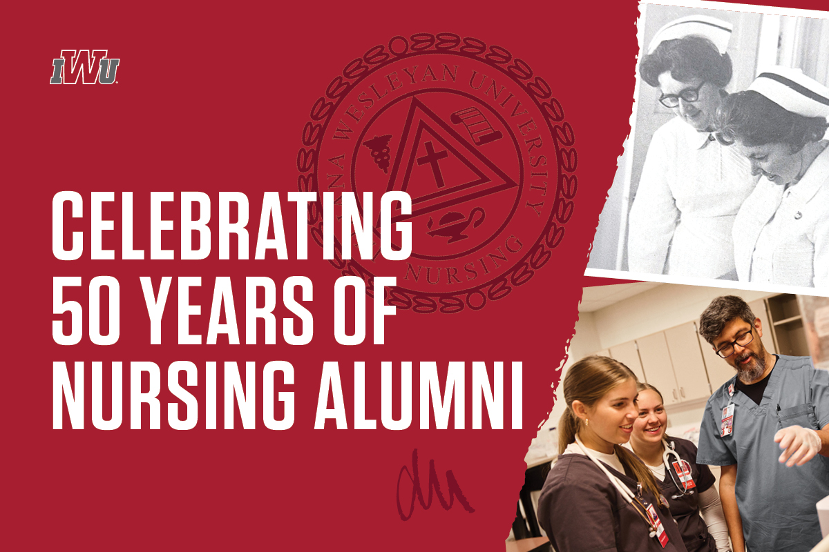 Principal smiling in front of camera while holding a clipboard. High school students are walking in the hallway behind her