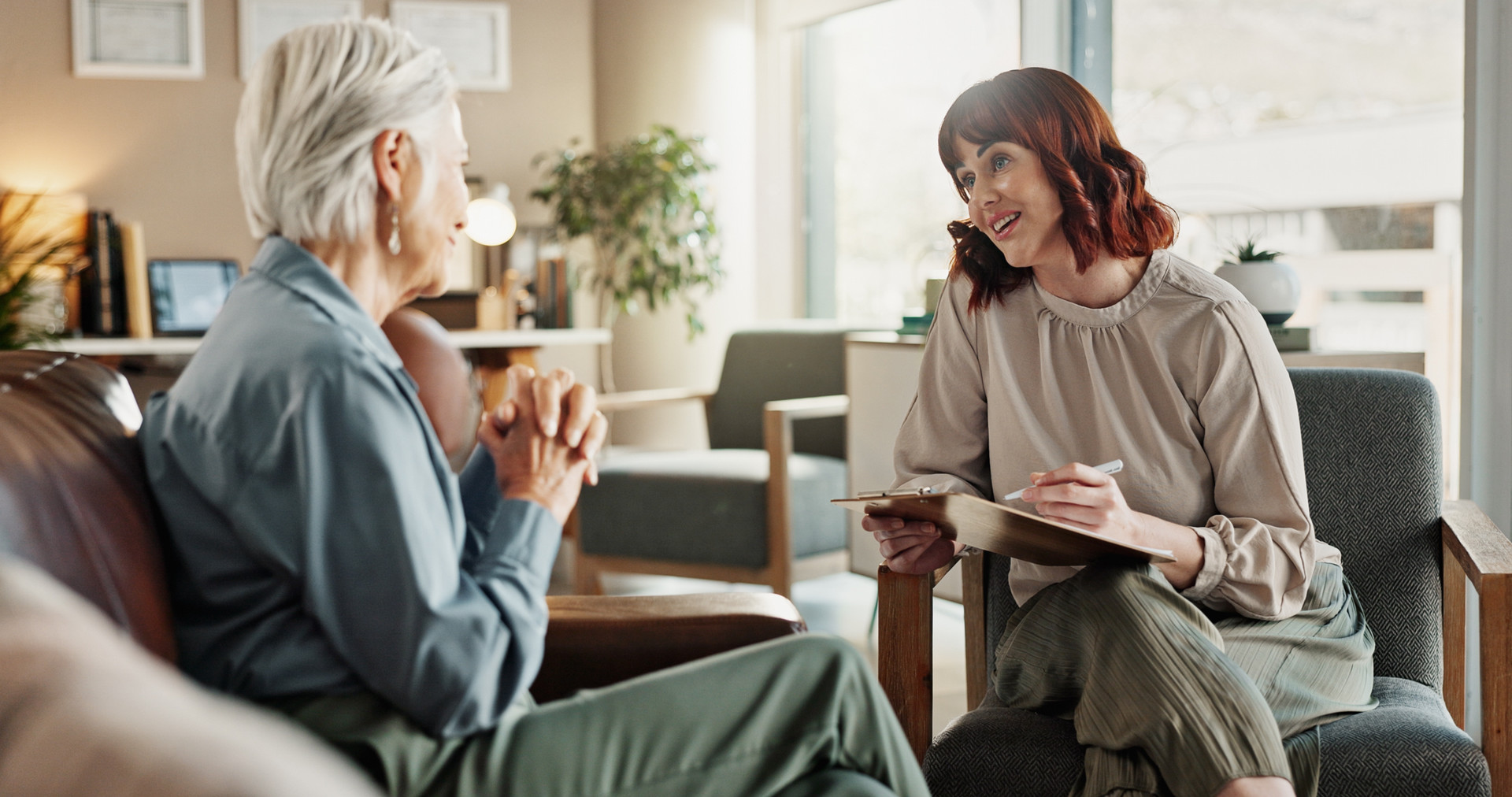 A woman speaking with counselor while sitting adjacent on couch