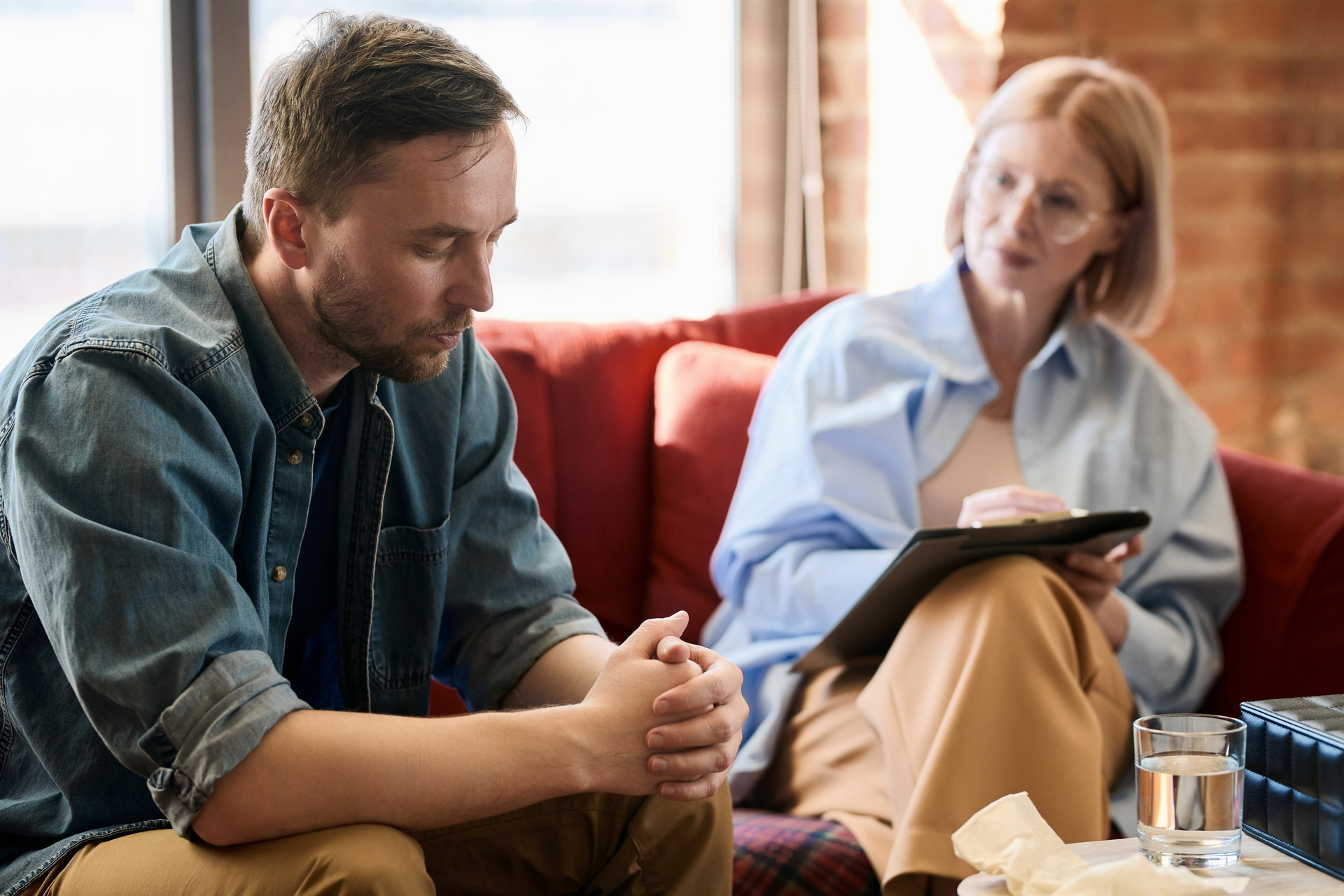Man sitting on couch while talking to counselor