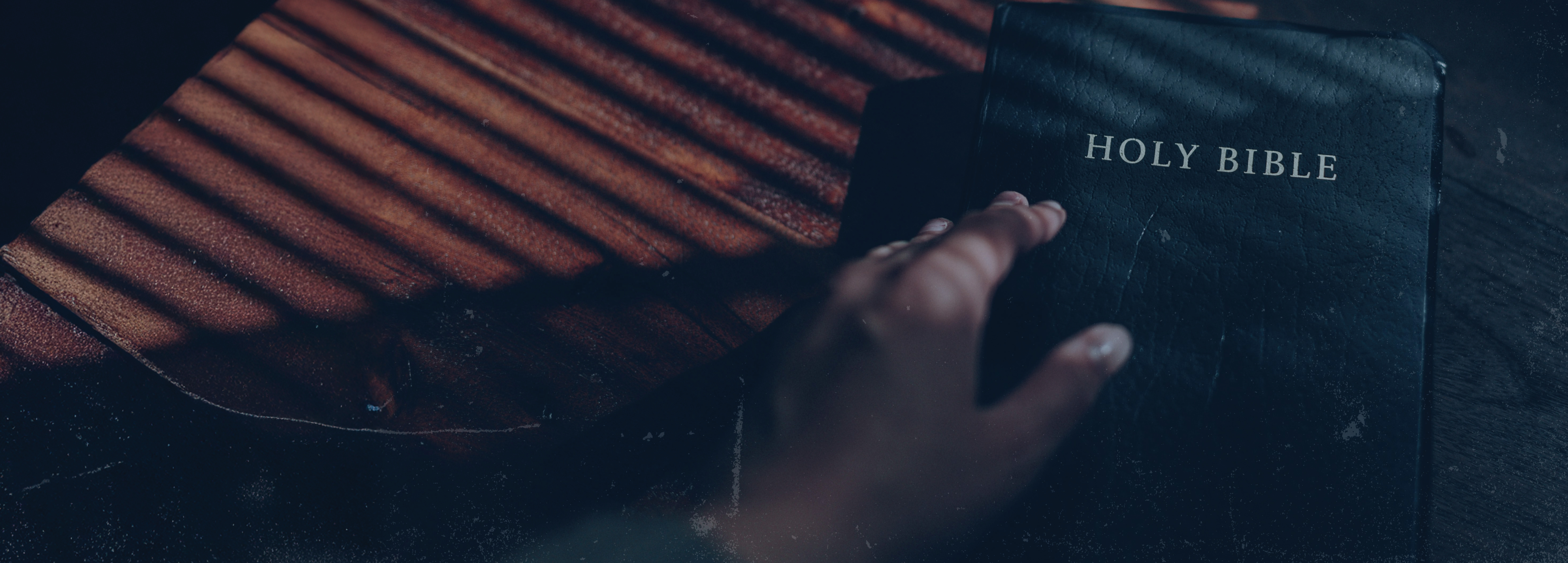 Black and White photo of bible cover with hand on top