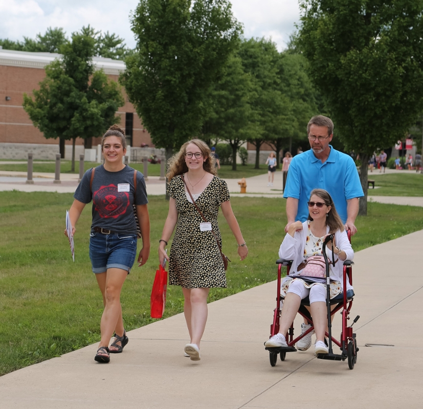 A family walks outdoors during a campus visit