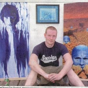 Tim Petrenic in front of three of his paintings