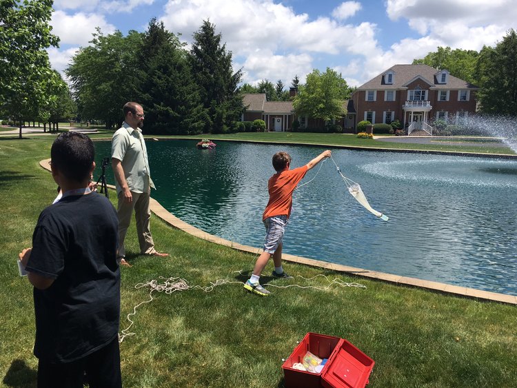 Children conducting an experiment near pond