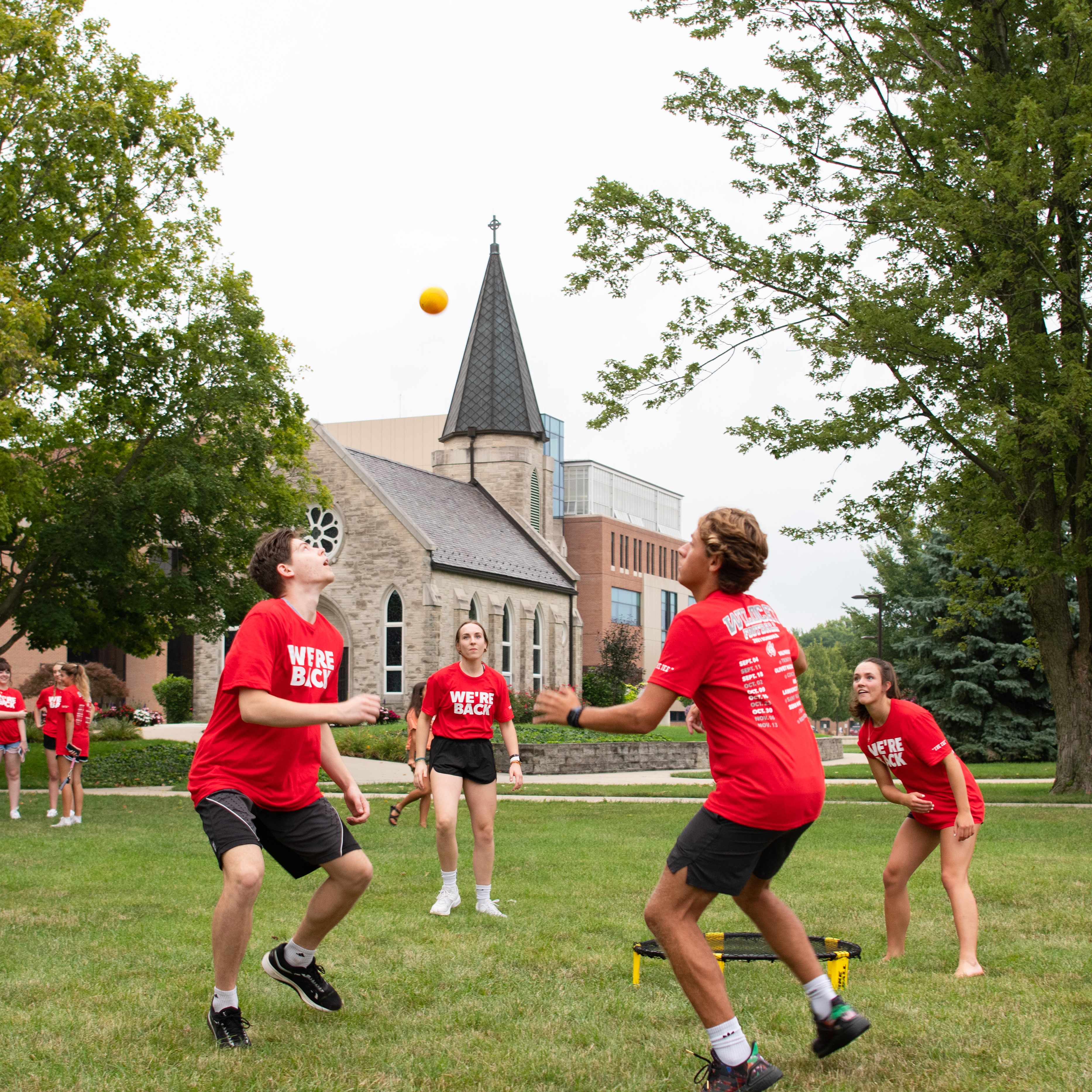 A group of students play a ball game on campus